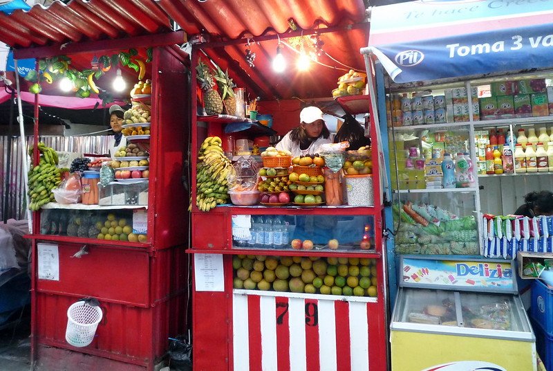 Vivandera vendendo frutas en un mercado de Bolivia